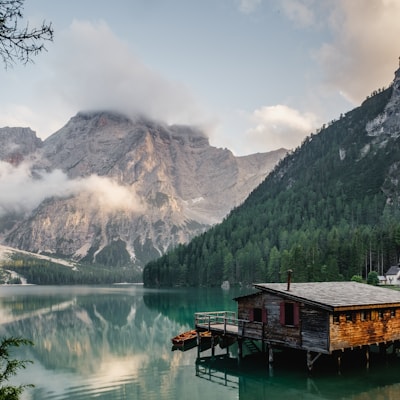Alpine lake with a wooden cabin and mountains