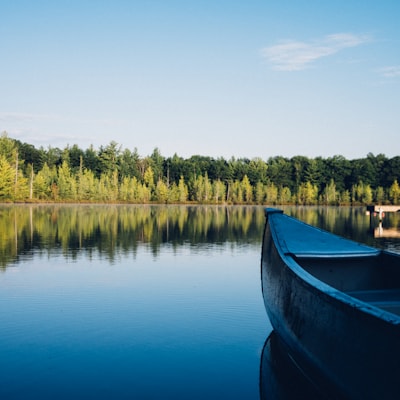 Calm forest lake with a canoe at the shore