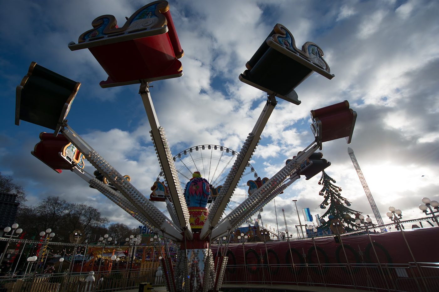 Sleigh-shaped ride seats and a Christmas tree, seen from below, before the preset